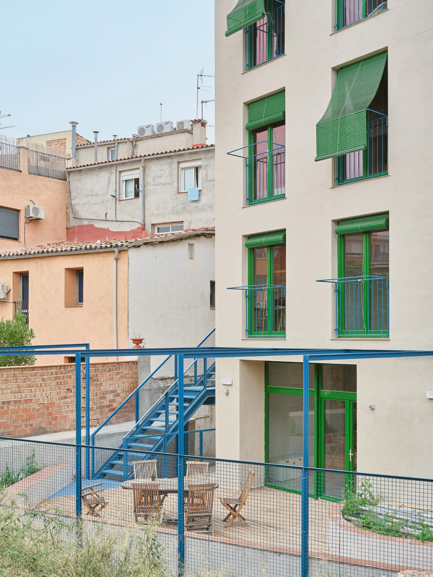 Fachada con balcones y vegetación integrada en la arquitectura.